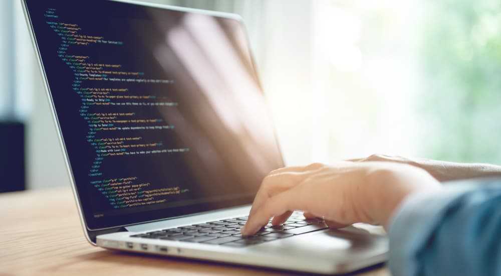 A laptop screen is displaying HTML text.