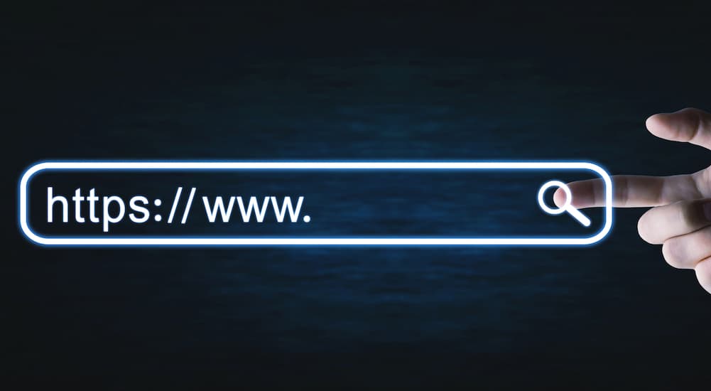 A hand is clicking a virtual url that has an SSL Certificate to show https, on a black background.
